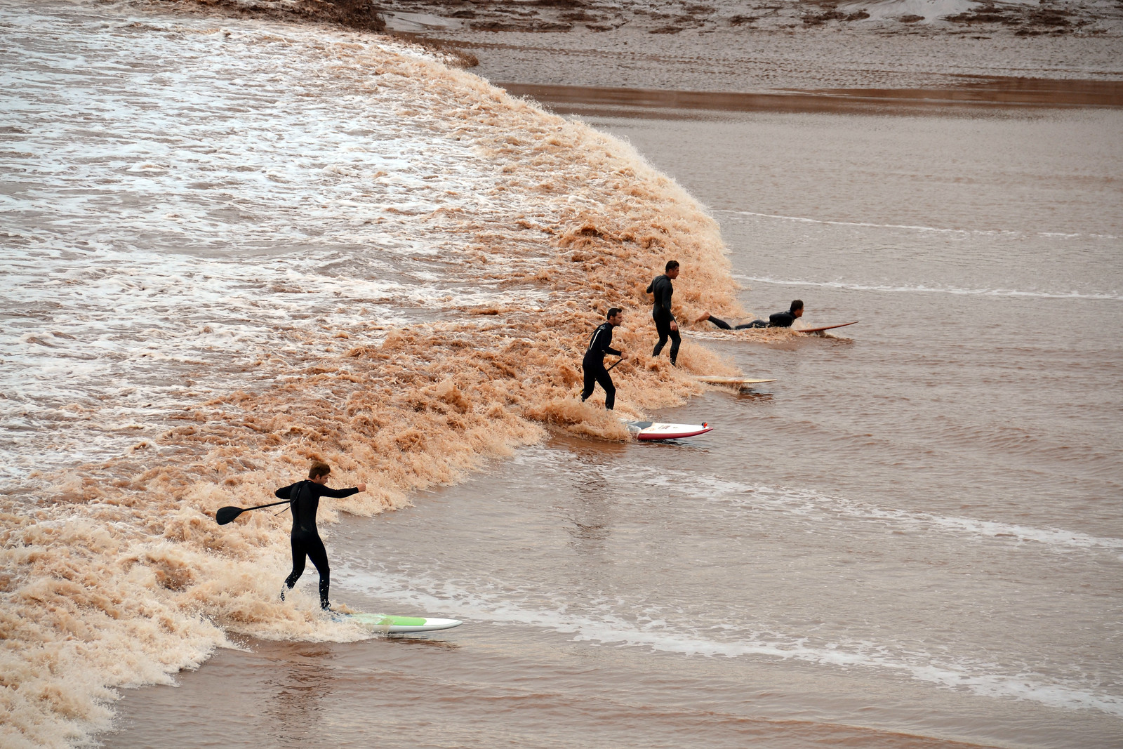 Surfers and kayakers riding in the tidal bore at the Moncton bore park